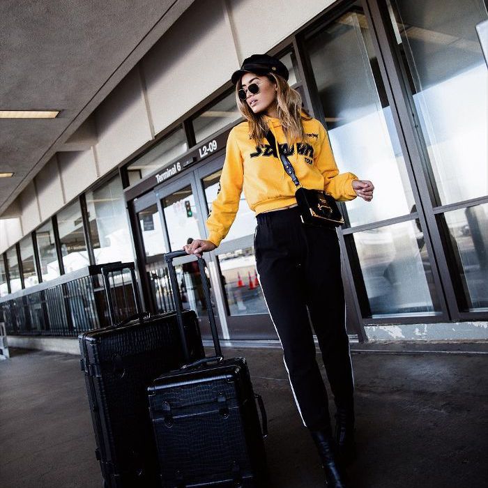 酷机场衣服与黑色的裤子