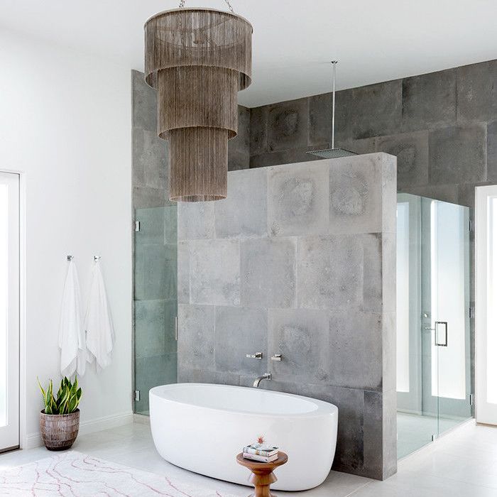 独立浴缸上方有大吊灯的浴室