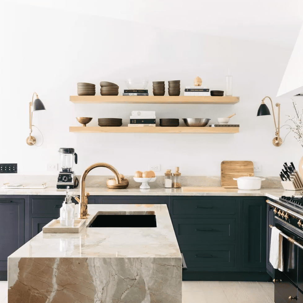 一个极简风格的厨房，有深绿色的橱柜和一个大理石的厨房岛台
