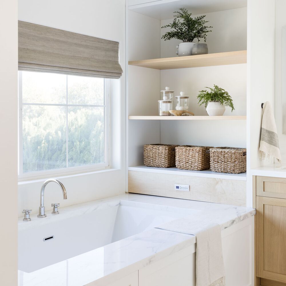 一间带内置滴管架的全白色浴室