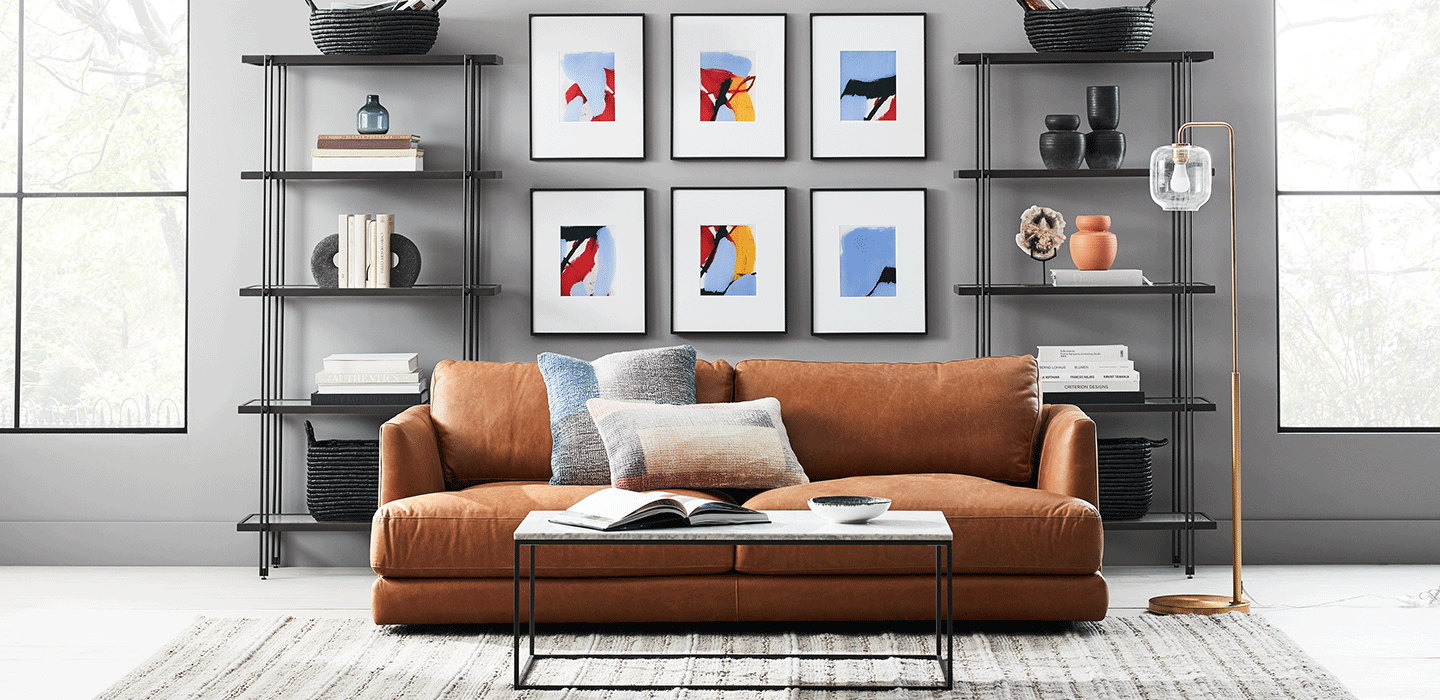 在对称的货架和画廊的墙壁前的皮沙发