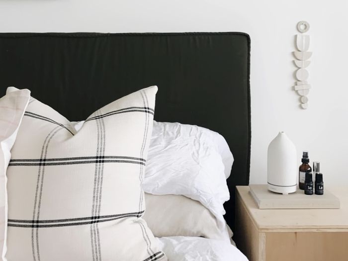 床头柜上有扩散器的床。