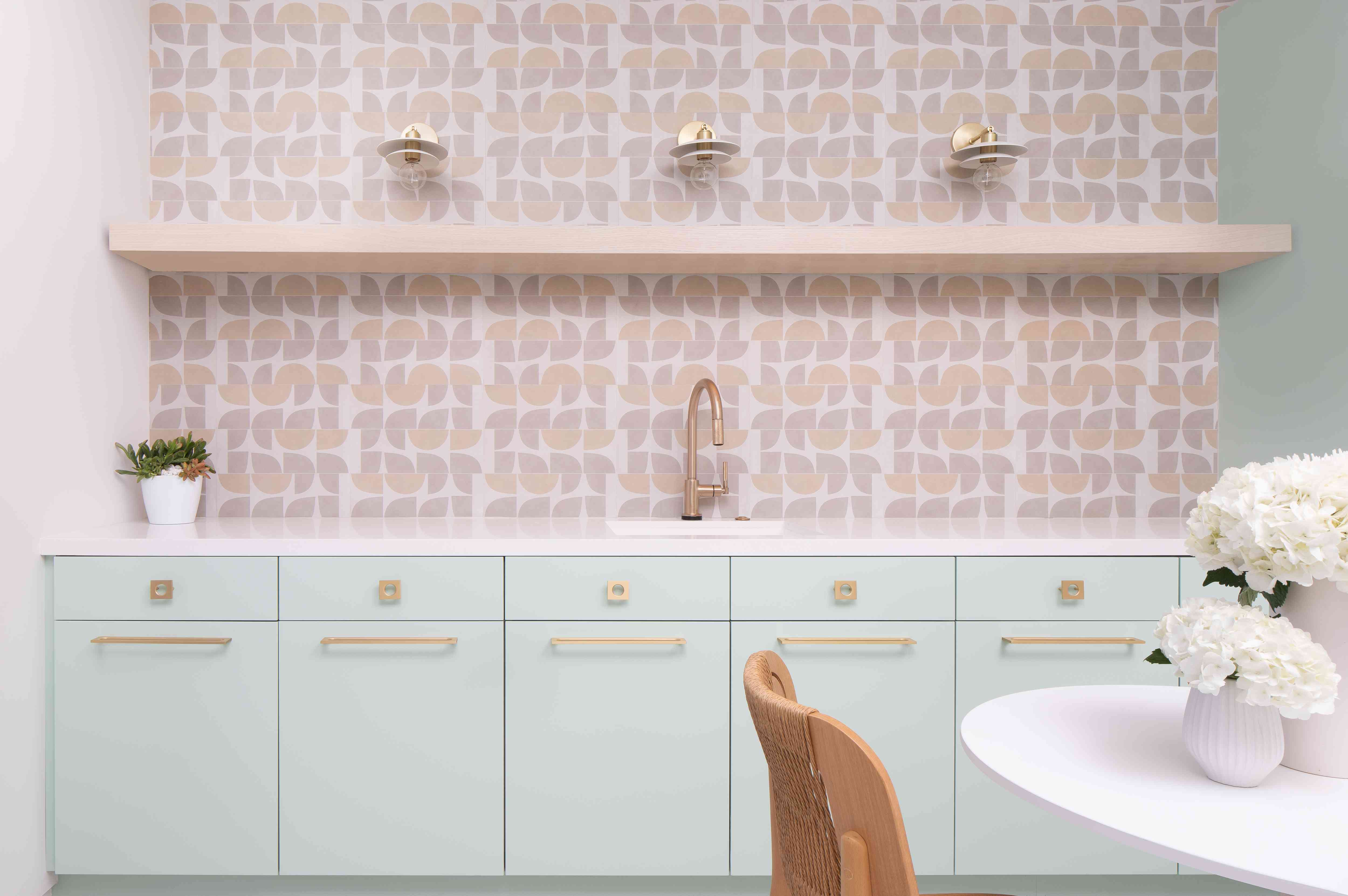 薄荷绿色的橱柜和粉红色瓷砖后挡板。