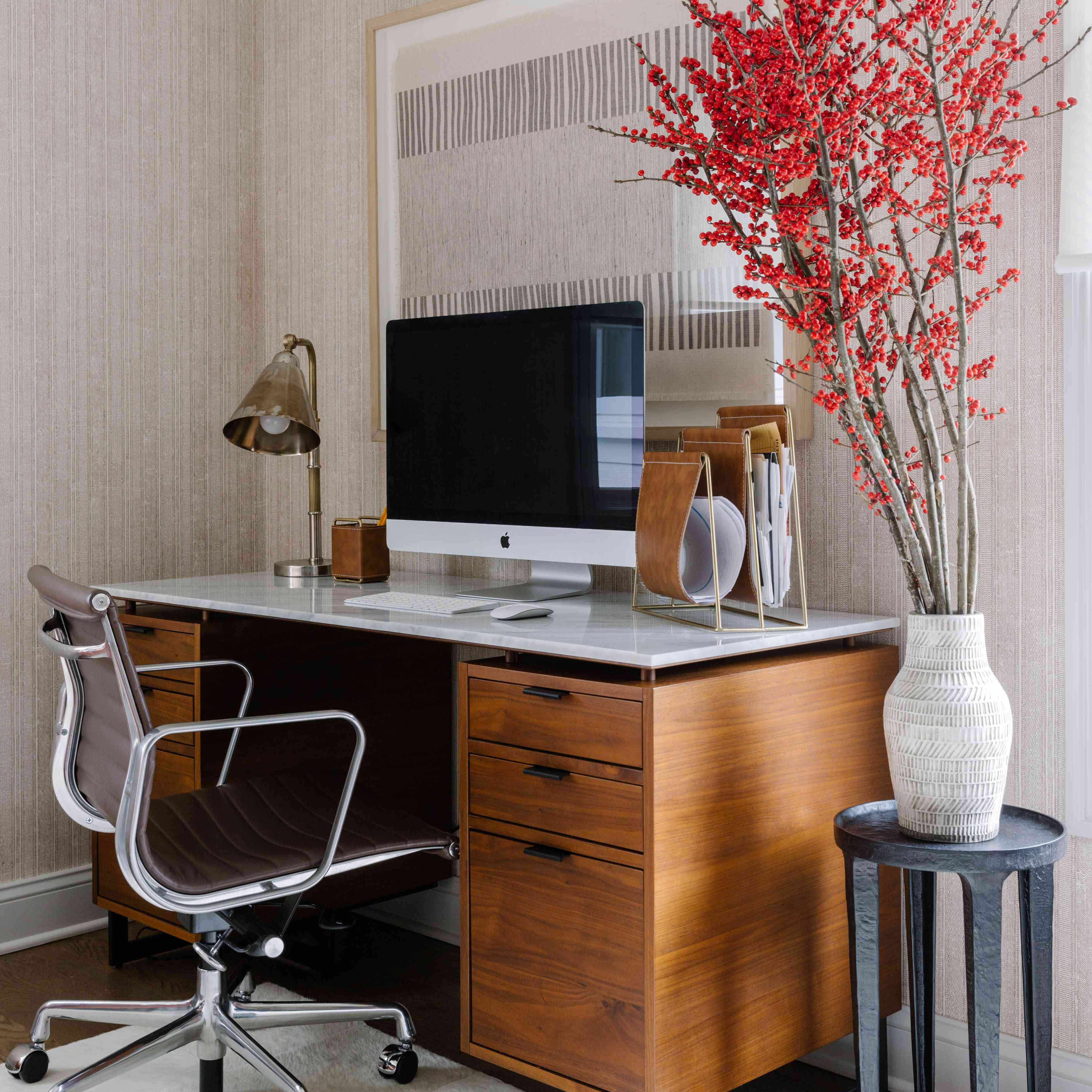 有木制办公桌和墙纸的办公空间。