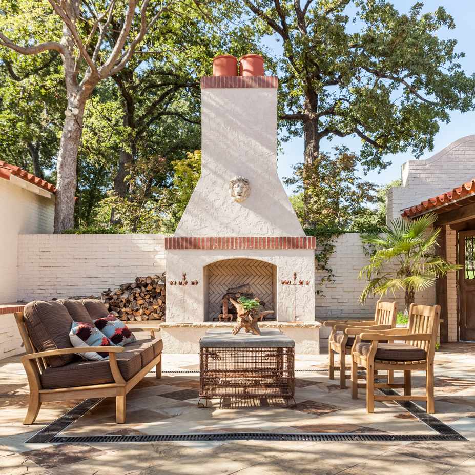 一个由白色灰泥和红砖制成的户外壁炉，与一个由白色砖和红色灰泥制成的家庭相连