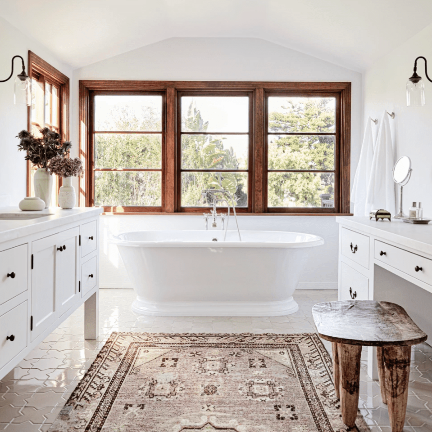 浴室配有独立式浴缸和印花粉红色地毯