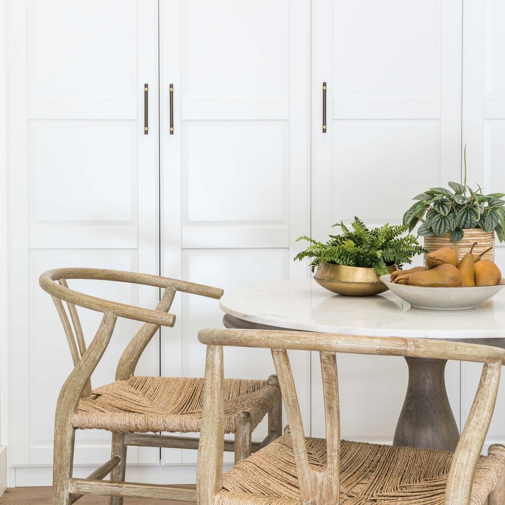 一个白色的厨房故事，上面有两株植物和一碗梨