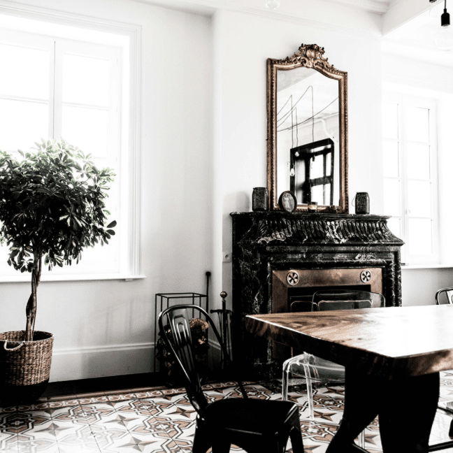 一间带维多利亚女王大理石壁炉和现代照明灯具的用餐室