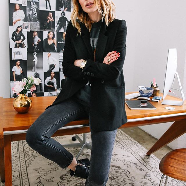 一个女人坐在桌子上，面前是时尚剪报。