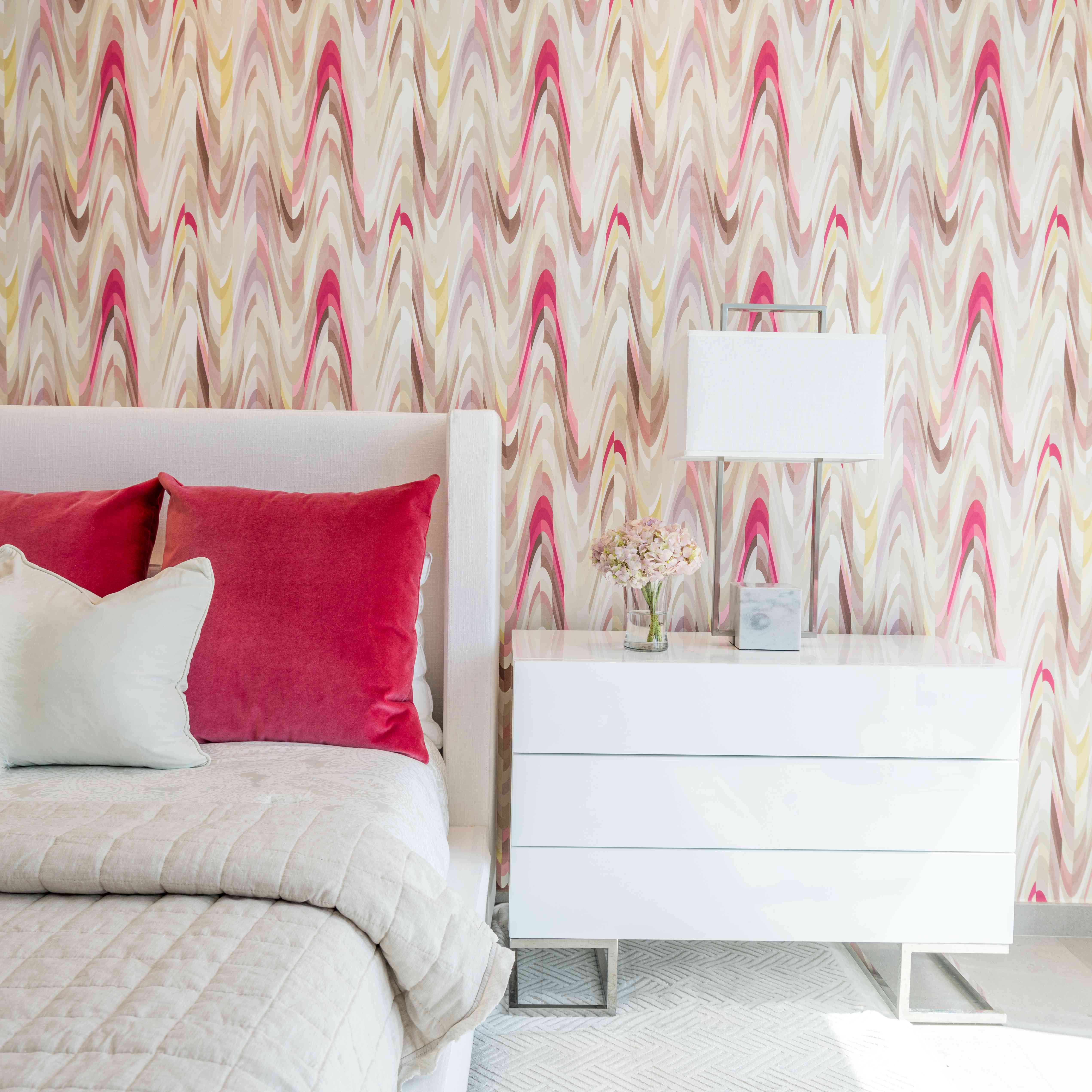 欢乐装饰-粉红色图案墙纸背后的白色床与热粉红色天鹅绒枕头