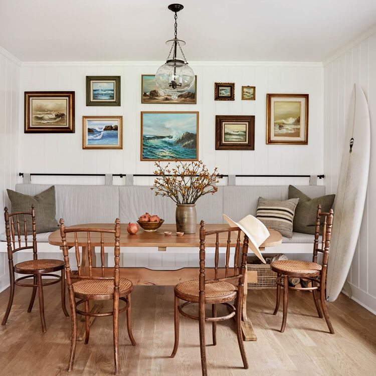 餐厅，带光滑的木制家具，一个大冲浪板和海洋绘画的画廊墙