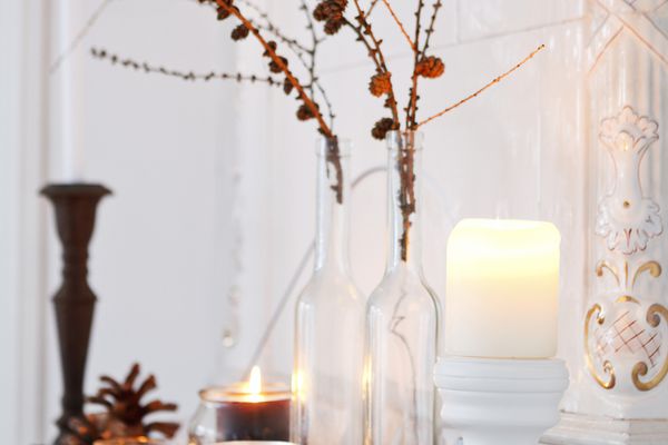 在地幔上的蜡烛和pinecone装饰