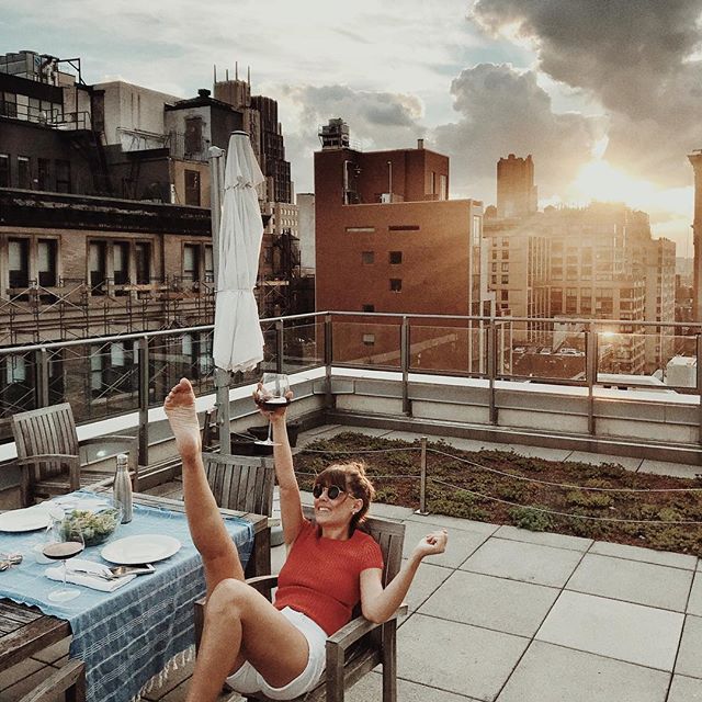 一个女人坐在屋顶上，而踢了一条腿和微笑。