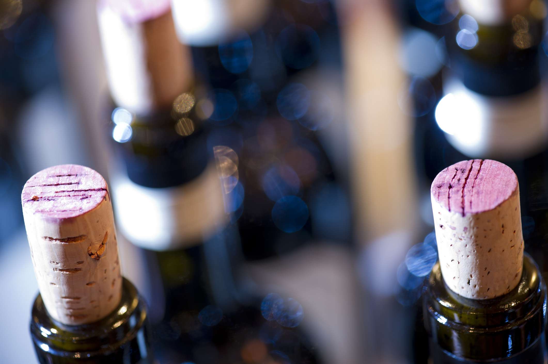 红色酒瓶的瓶塞部分被移开的特写。