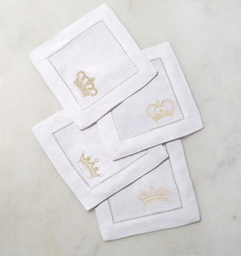 一套四张方形亚麻鸡尾酒餐巾纸，每张餐巾纸的角上都缝上了皇冠。