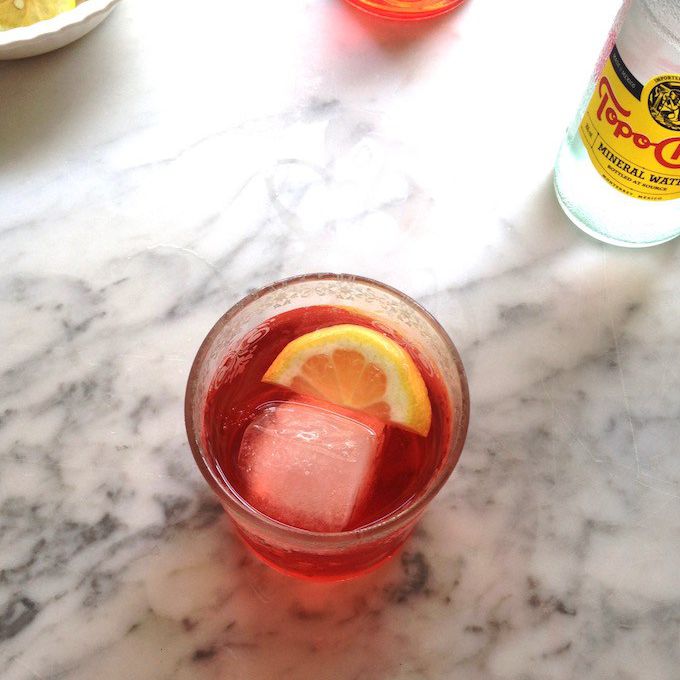 在具有大冰块和柠檬楔玻璃甲汽酒。