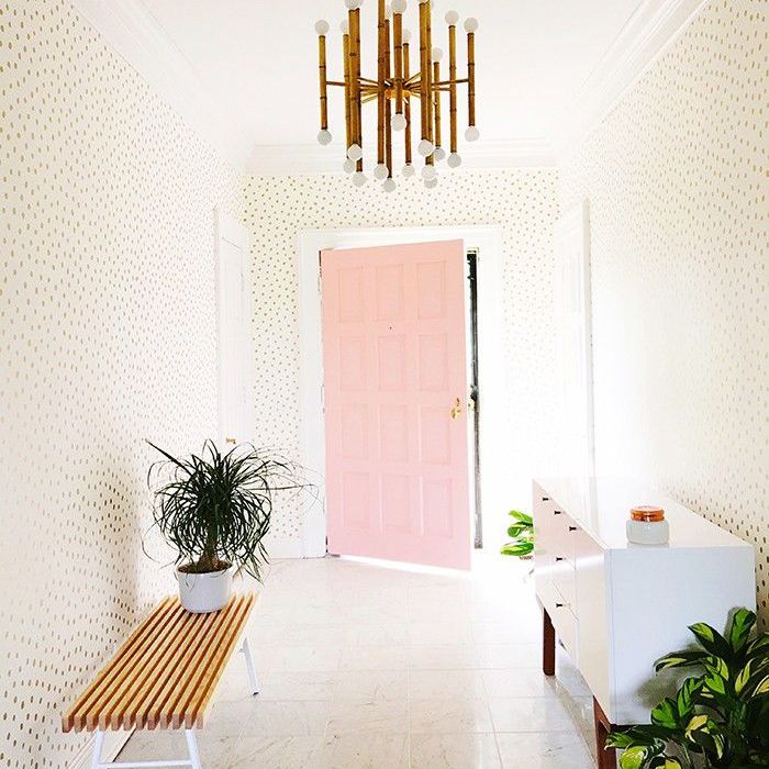 入口通道，有一扇粉红色的门和墙纸