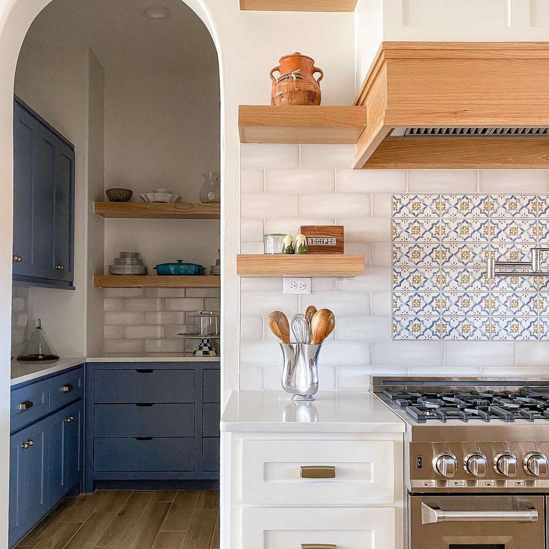 厨房配有拱门和蓝色和白色橱柜。