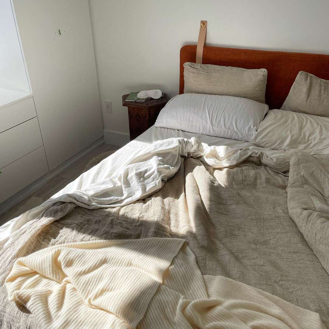 与白色和棕色床单的杂乱床。