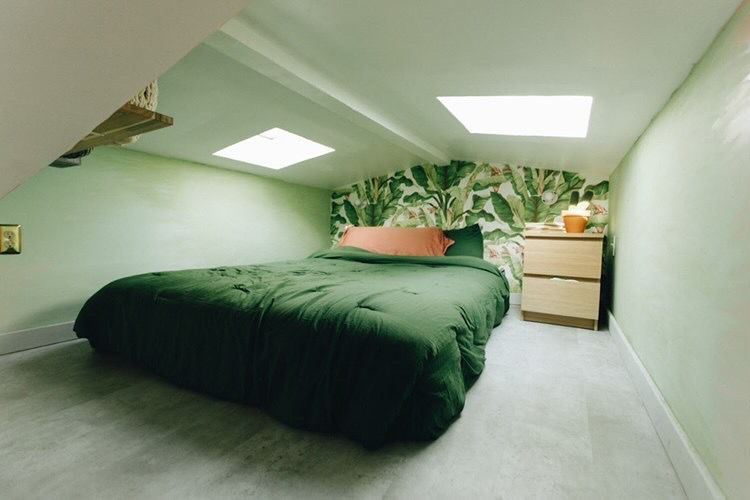 有绿色叶茂盛墙纸的微小的家庭卧室。