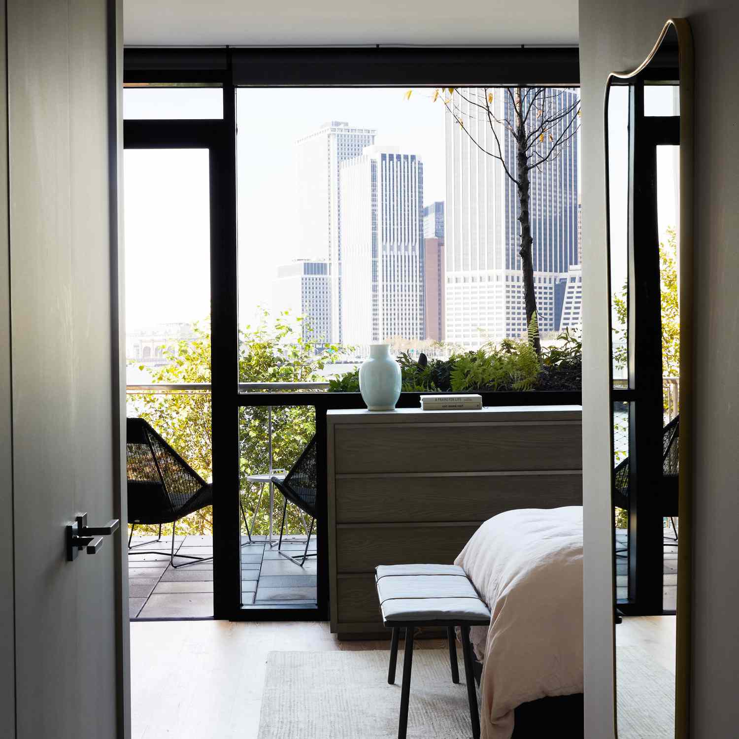 一间卧室通向一个用醒目的黑色椅子装饰的阳台