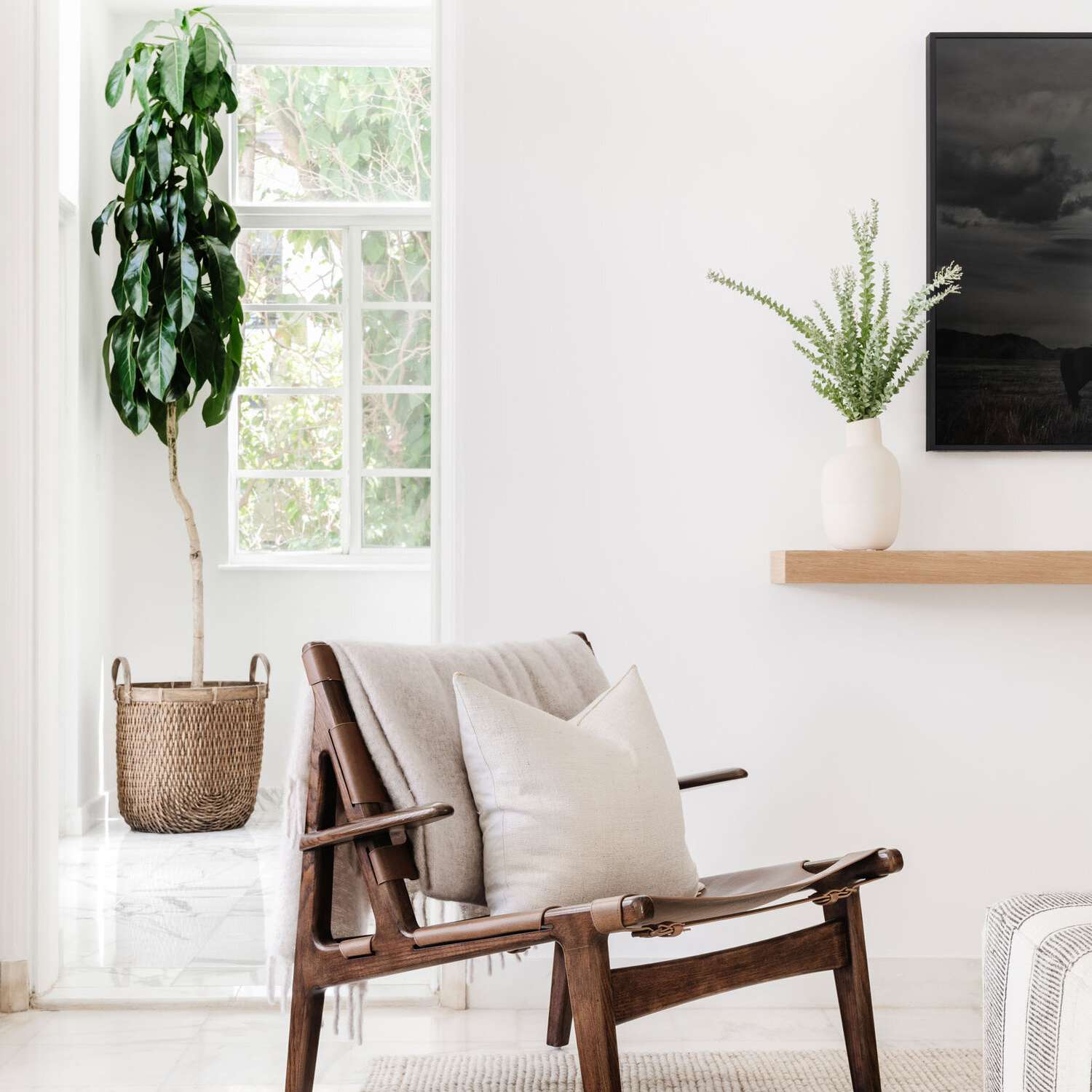 在摆满白色和灰白色纺织品的房间里，有一把亚麻衬里的椅子