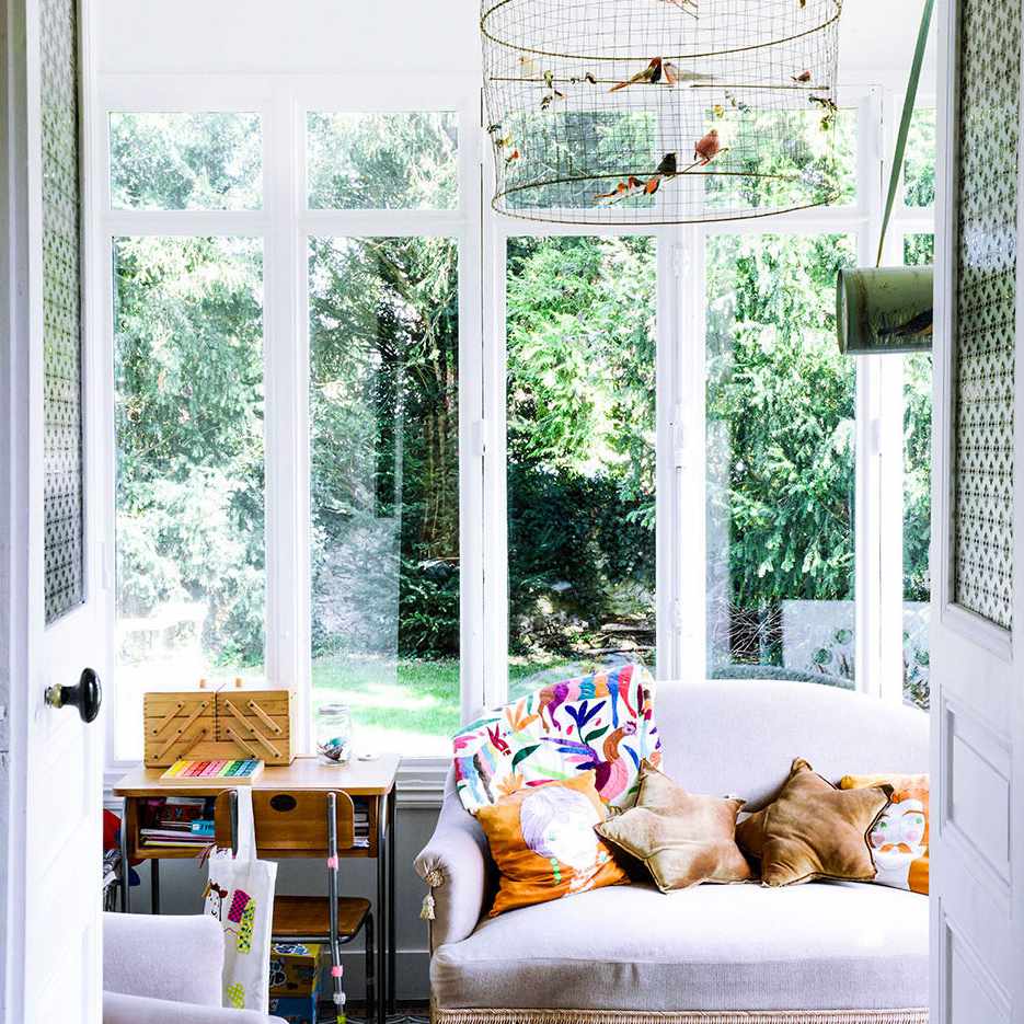 日光浴室配有华丽的复古沙发和鸟笼。