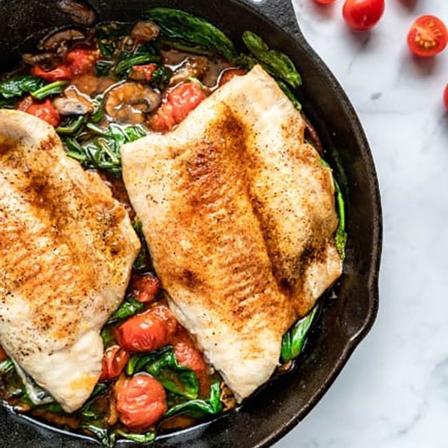 白鱼片与西红柿和菠菜一起放在平底锅中