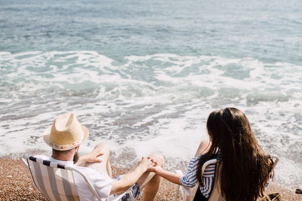 握手的一对夫妇，当坐海滩时