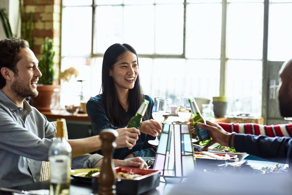 敬酒在餐桌附近的小组青年人