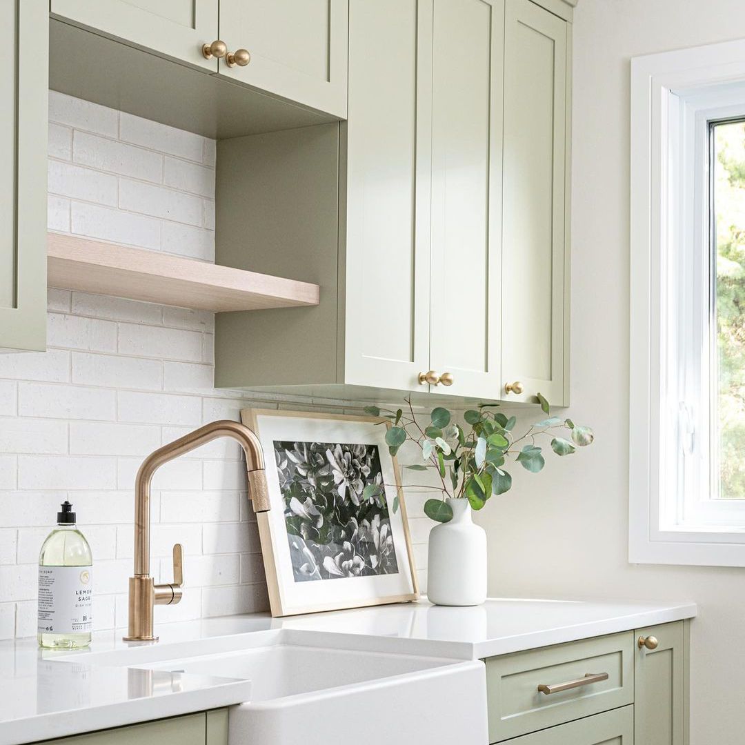 Laundry room with light green cabinetry