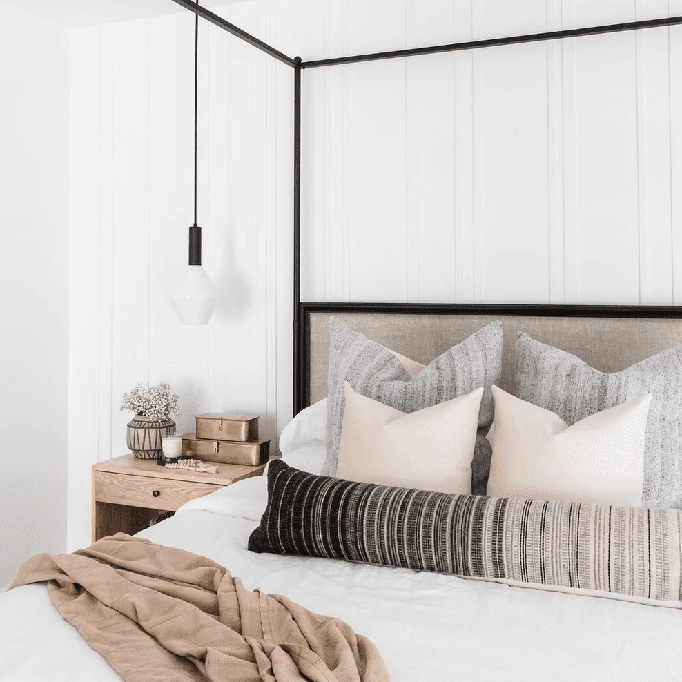 一间带黑色冠层床架和配套灯具的卧室