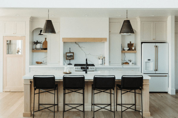有黑barstools的明亮的白色厨房。