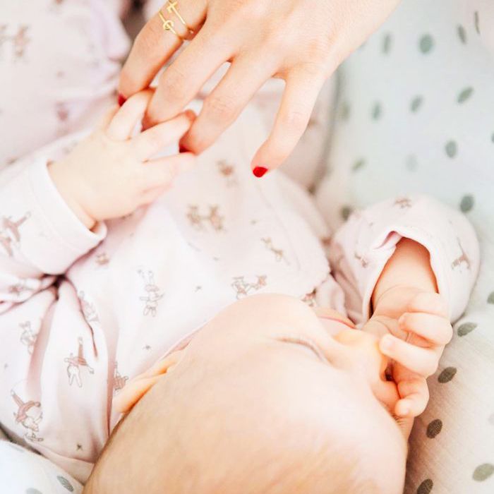 她的手一个女人与一个环让宝宝抱着她的手指。