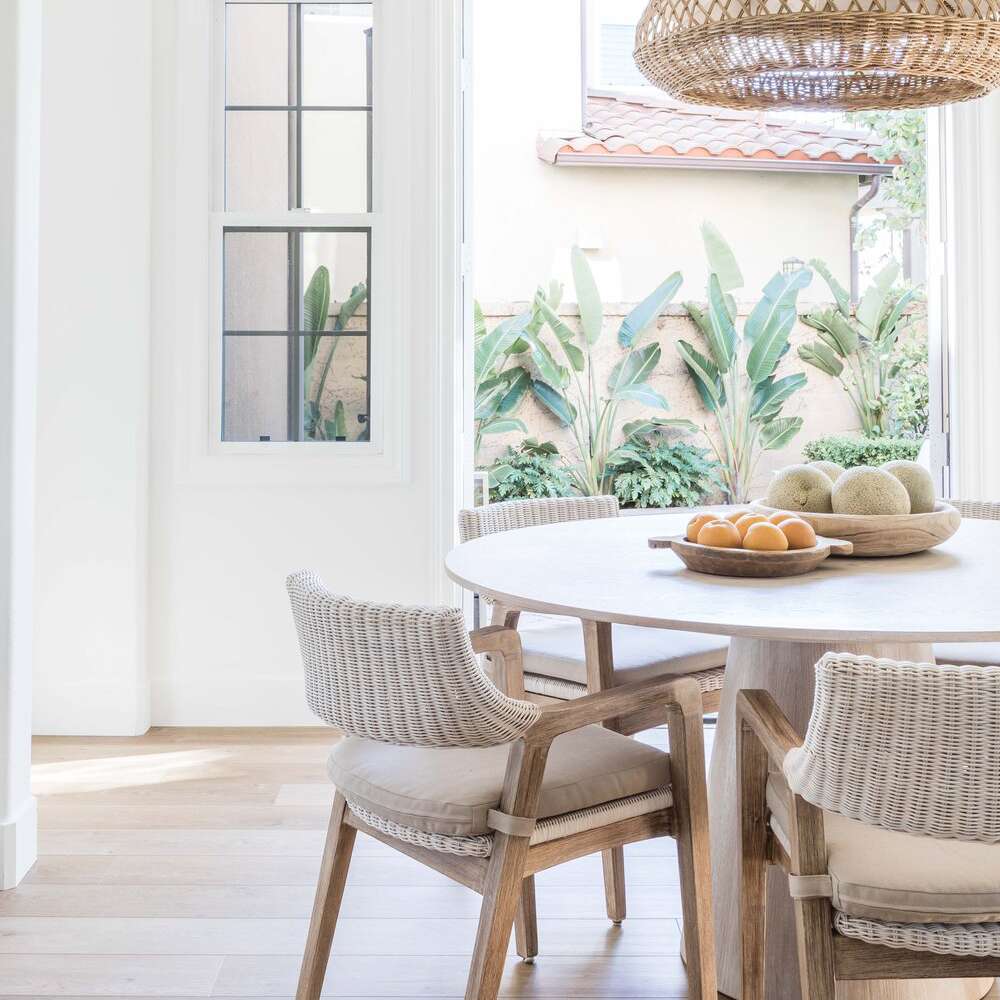 一张圆餐桌，上面放着两碗水果——一碗是橘子，一碗是哈密瓜