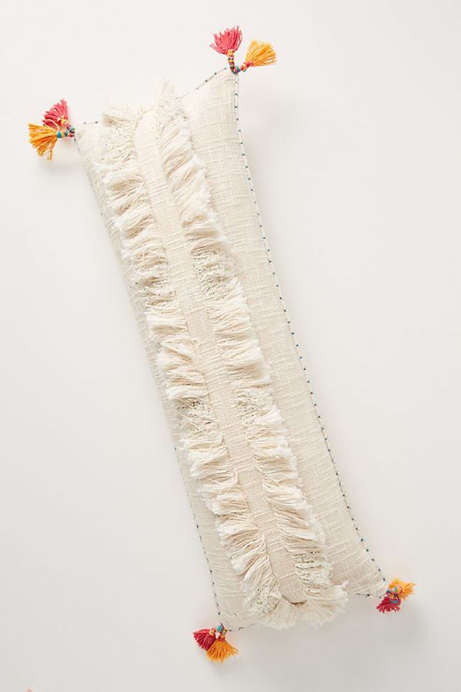 白色丛生腰枕与粉红色和橙色流苏。