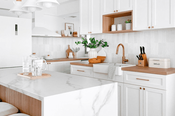 有白色橱柜、白色台面和白色吊灯的小厨房