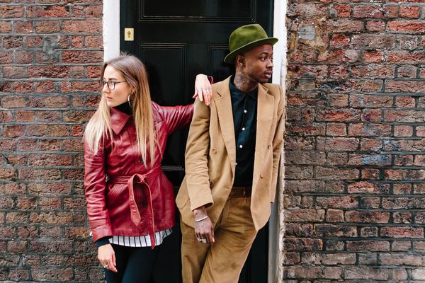 一对夫妇站在彼此相邻，看着不同的方向