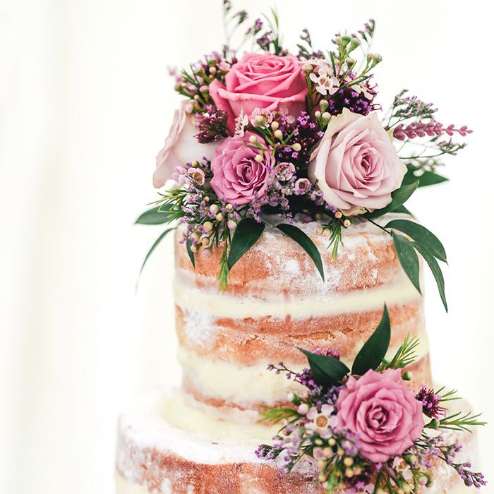 Multi-tiered wedding cake with pink flowers.