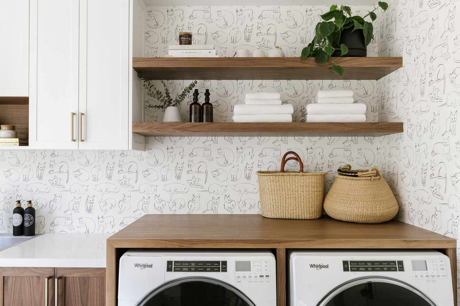 Laundry room with wall paper and shelving
