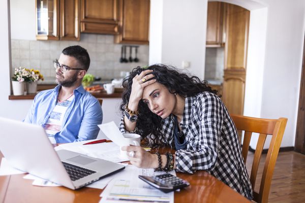 看起来在膝上型计算机前面的夫妇沮丧