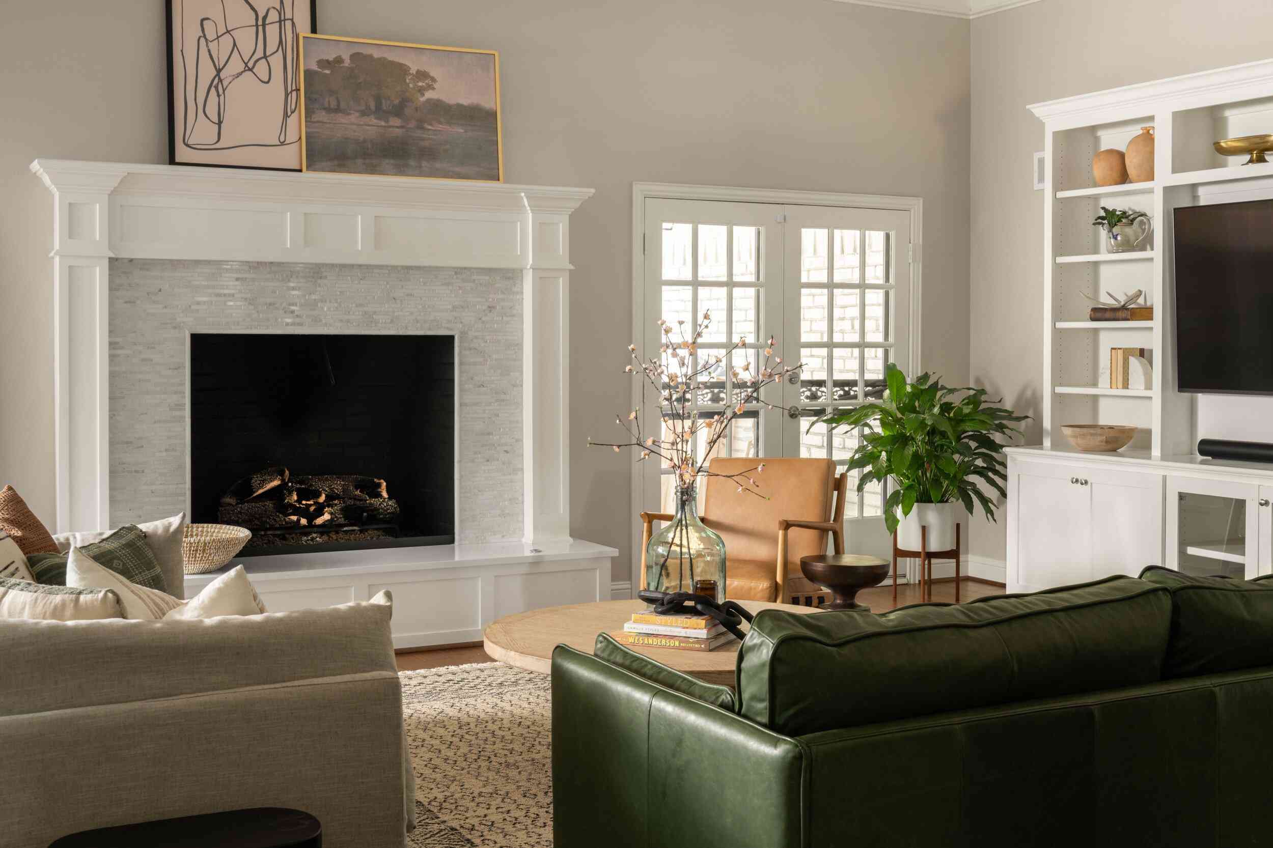 一个装满温暖的棕色和森林绿色皮革家具的起居室