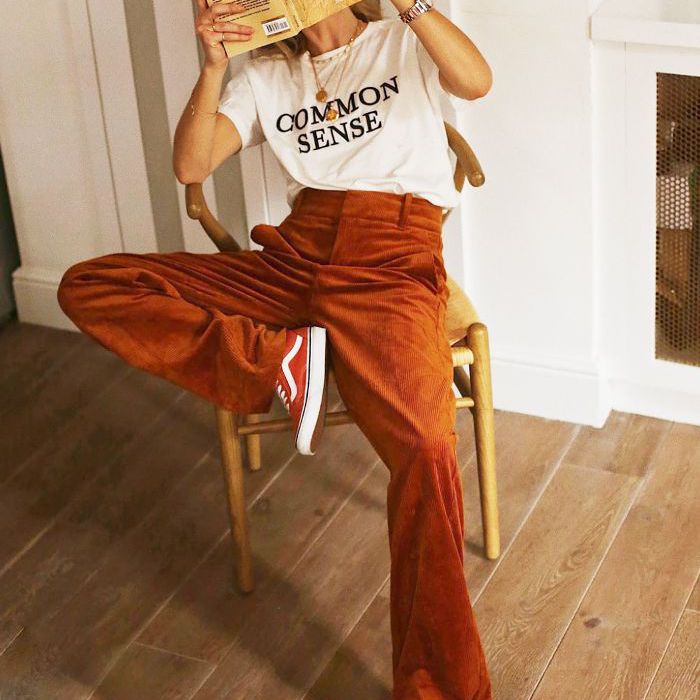 一个女人坐在椅子上一边看书。