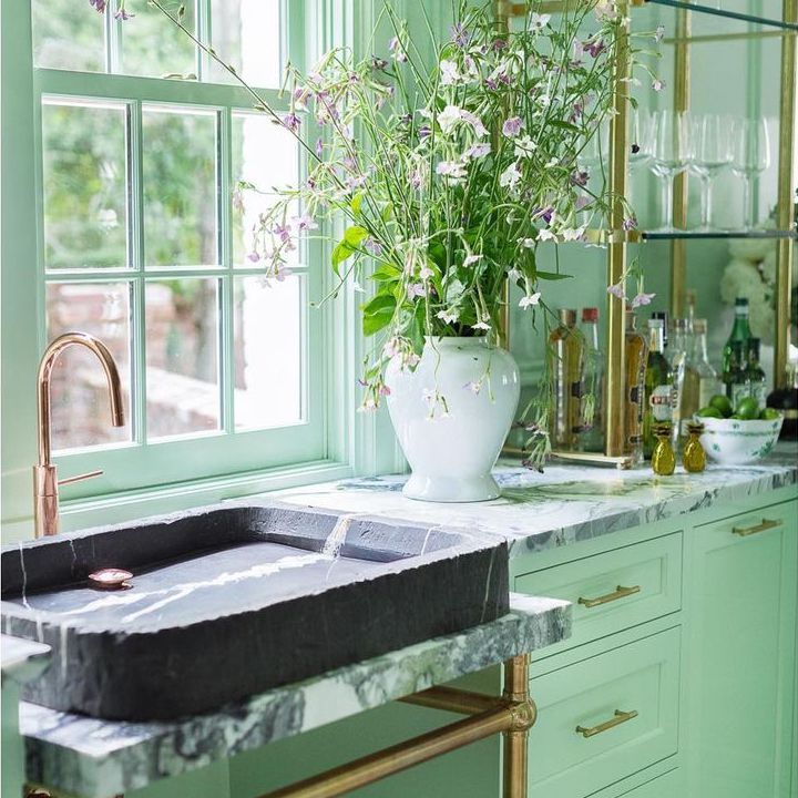 正式的薄荷绿色厨房与黄铜和玻璃开放式搁架