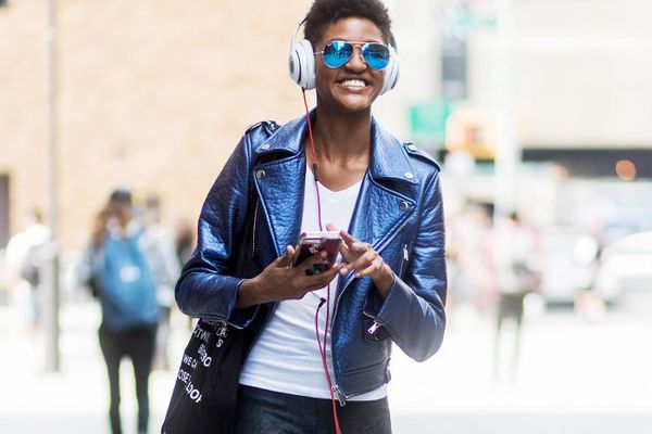 正在收听连接到手机的耳机的女士