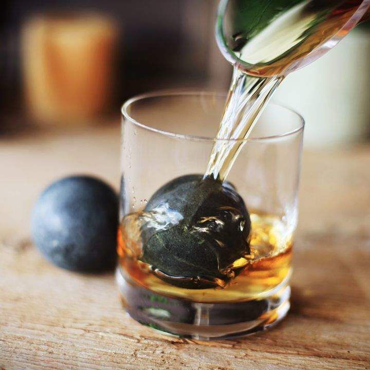 威士忌倒入具有大皂石球内的玻璃。