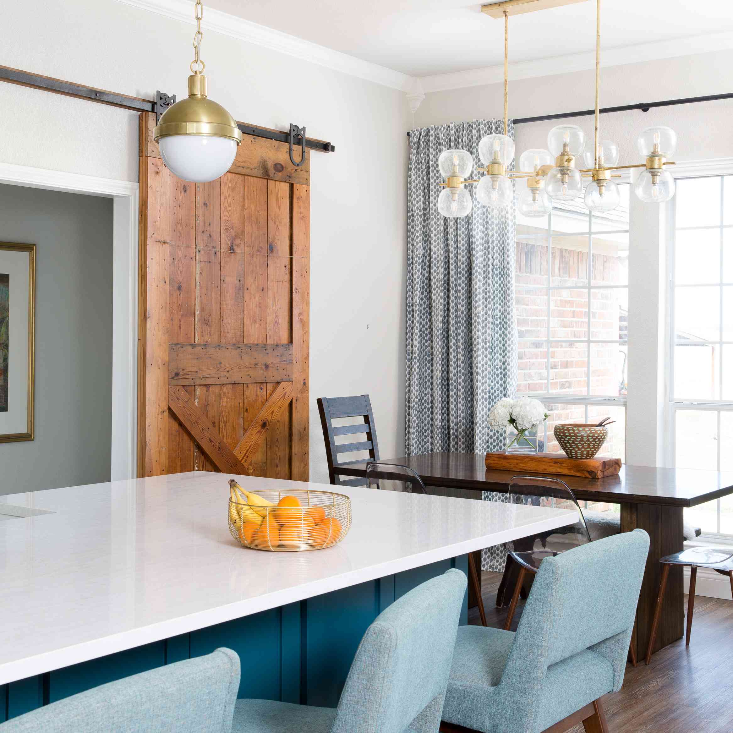 用金枝形吊灯灯和谷仓门的用餐区。