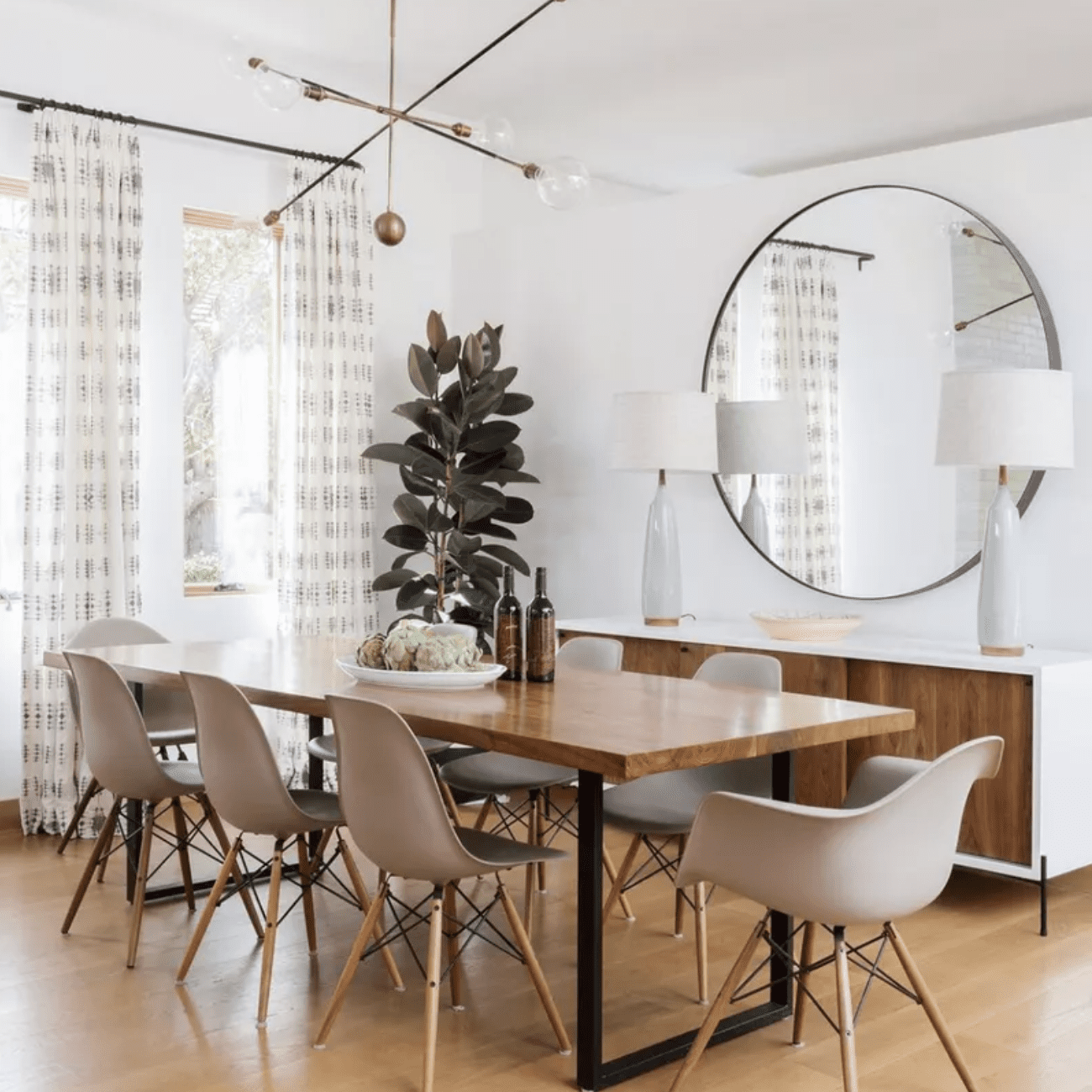 一间餐厅，黑色的铁幕杆上挂着印花窗帘，与房间里的其他硬件相匹配