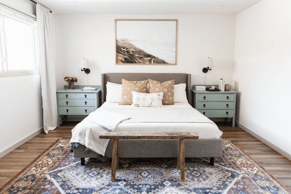 中性卧室配有鼠尾草绿色床头柜。