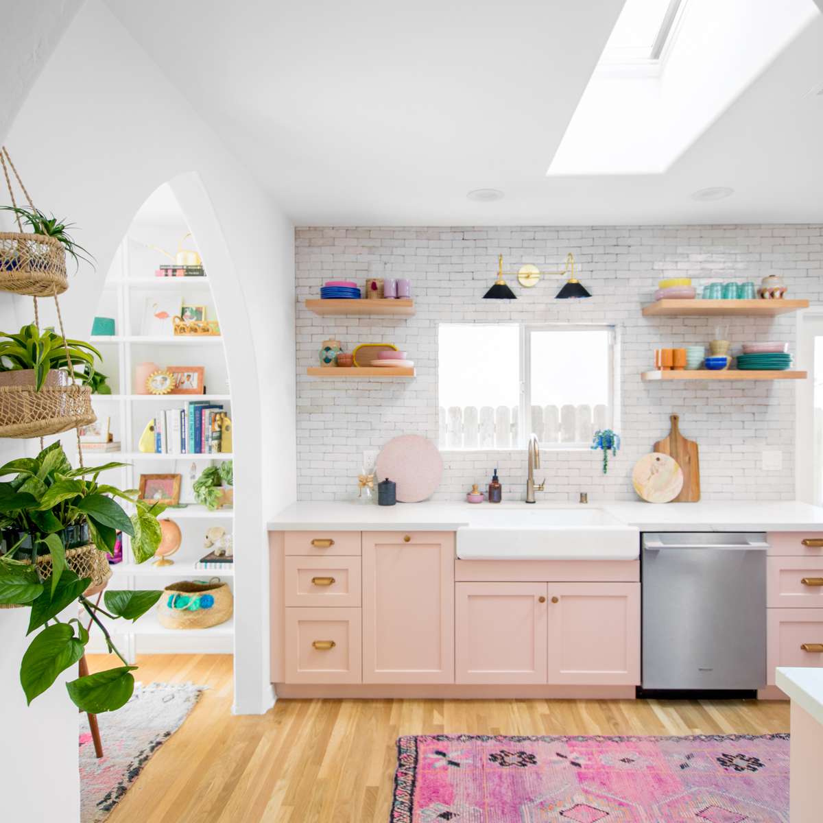 厨房里有植物和粉红色的橱柜。